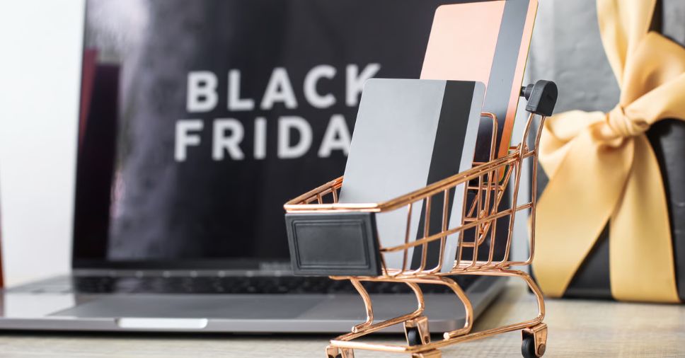 Computador e anúncio de Black Friday e carrinho de compras para falar de black friday para e-commerce.